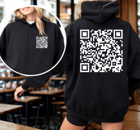 Person wearing a black hoodie with a QR code on the back, standing in a casual setting.